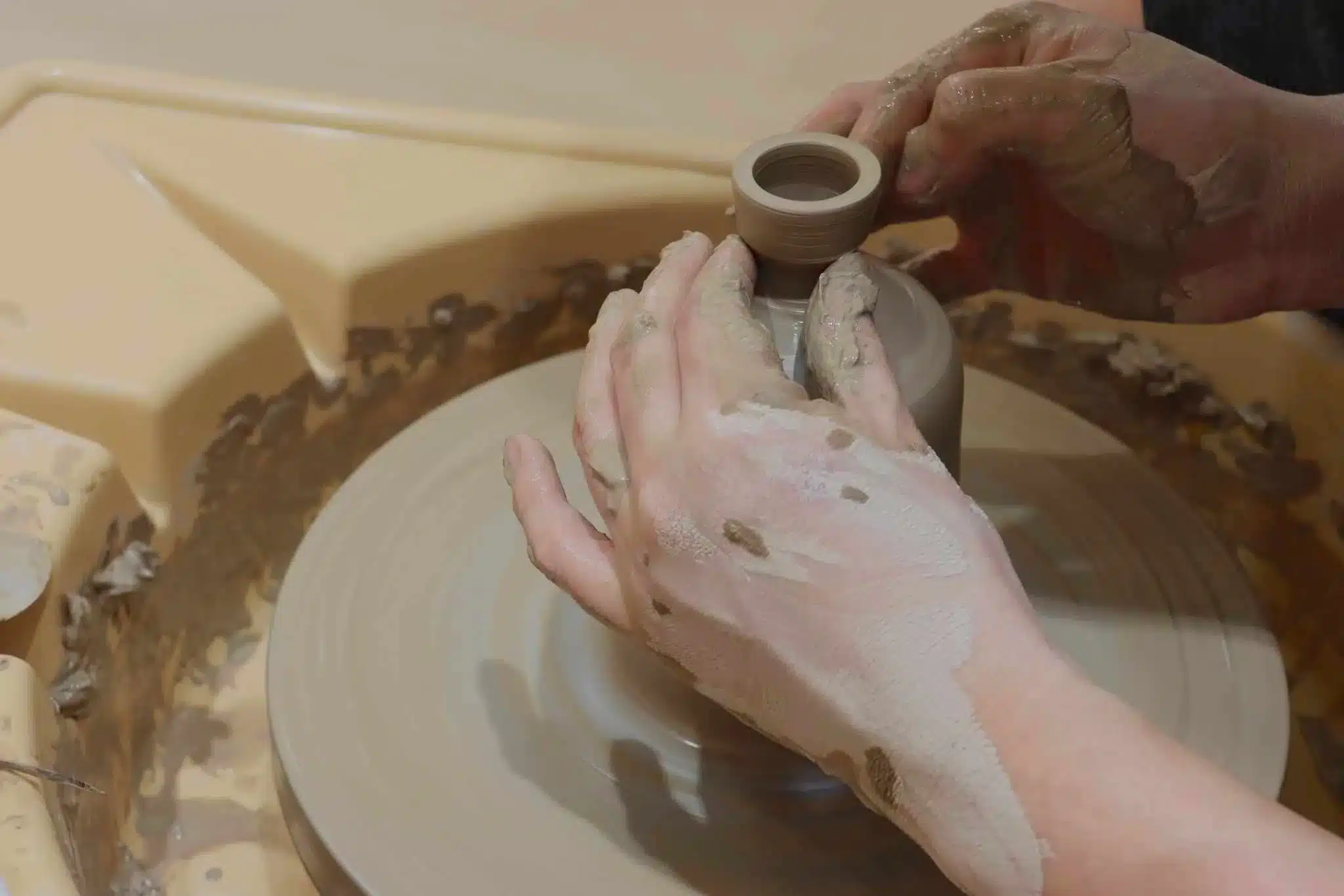 A workshop participant's hand crafted a vase